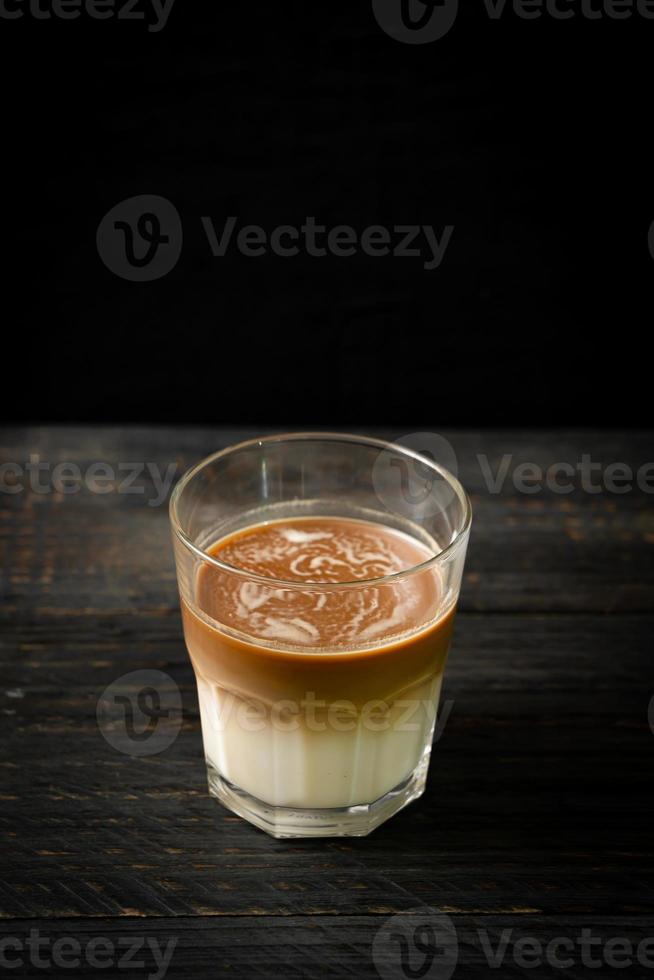 glas latte koffie, koffie met melk op hout achtergrond foto