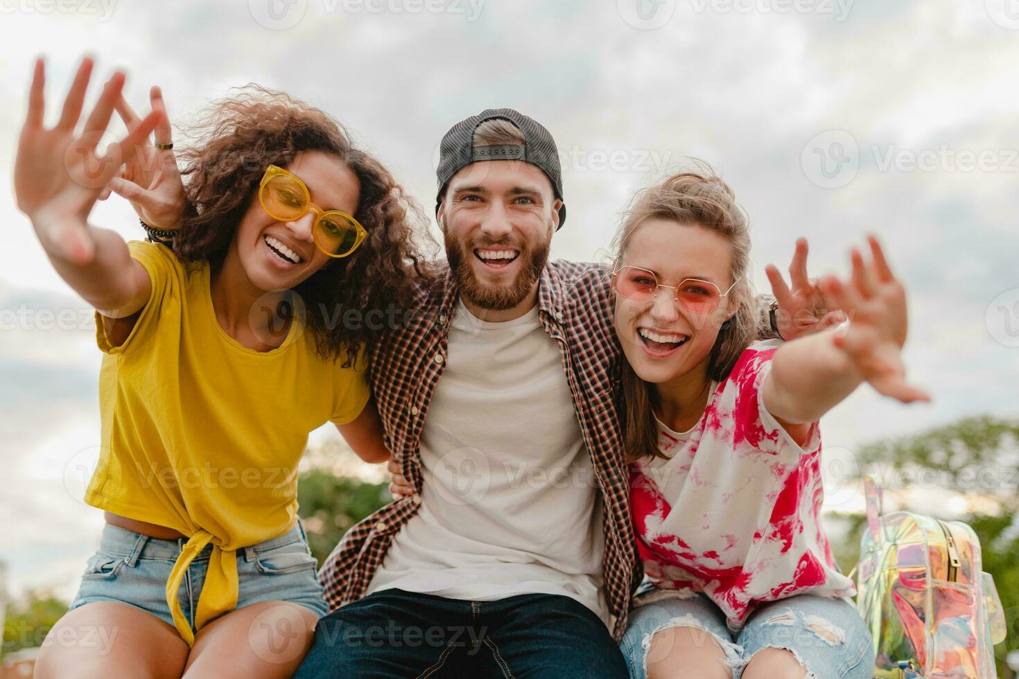 gelukkig jong bedrijf van glimlachen vrienden zittend in park foto