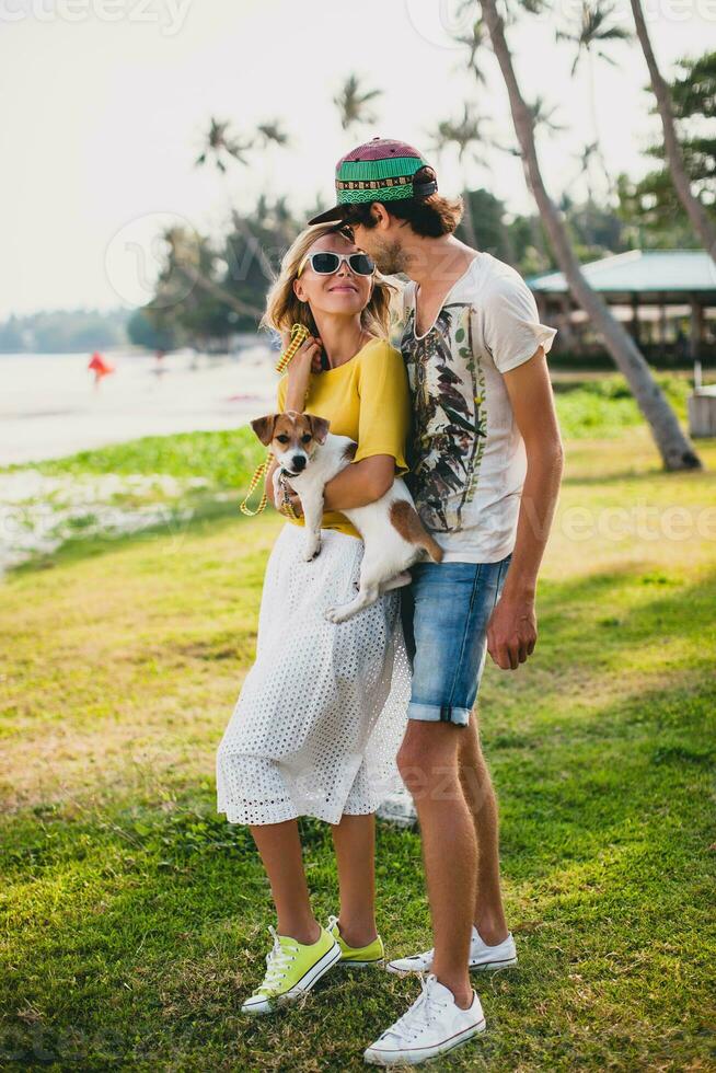 jong elegant hipster paar in liefde Holding een hond Bij de tropisch park foto