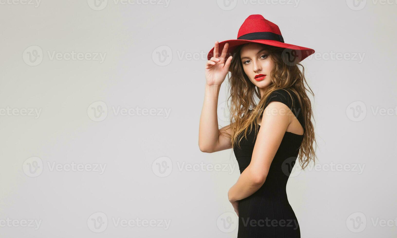 jong mooi elegant vrouw in zwart jurk, rood hoed foto