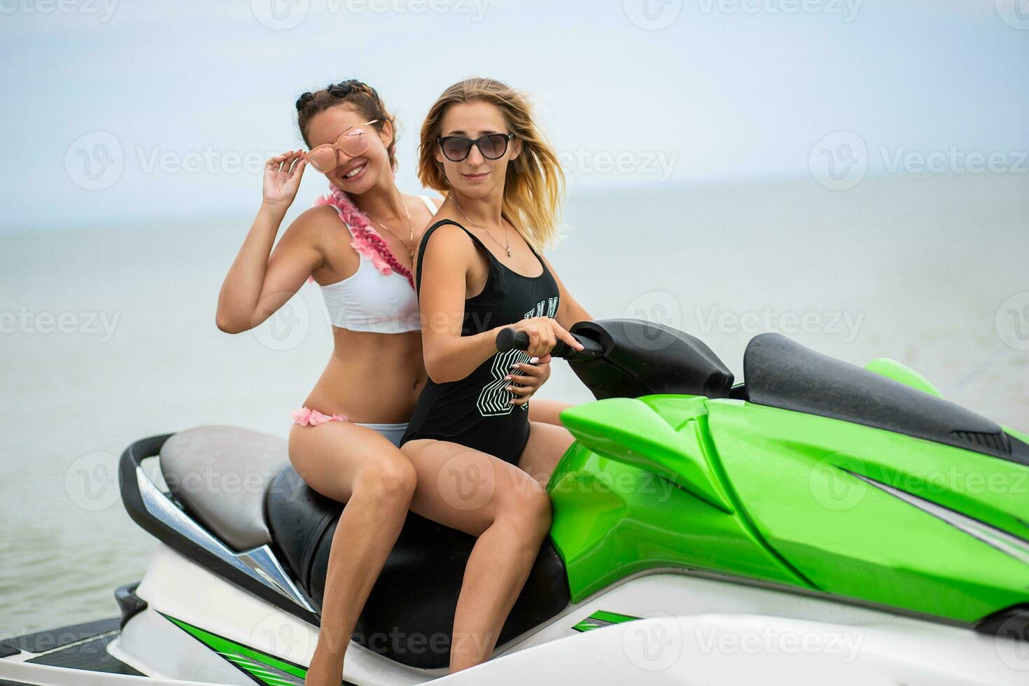 twee sexy Dames in bikini Aan water scooter in zee zomer stijl foto