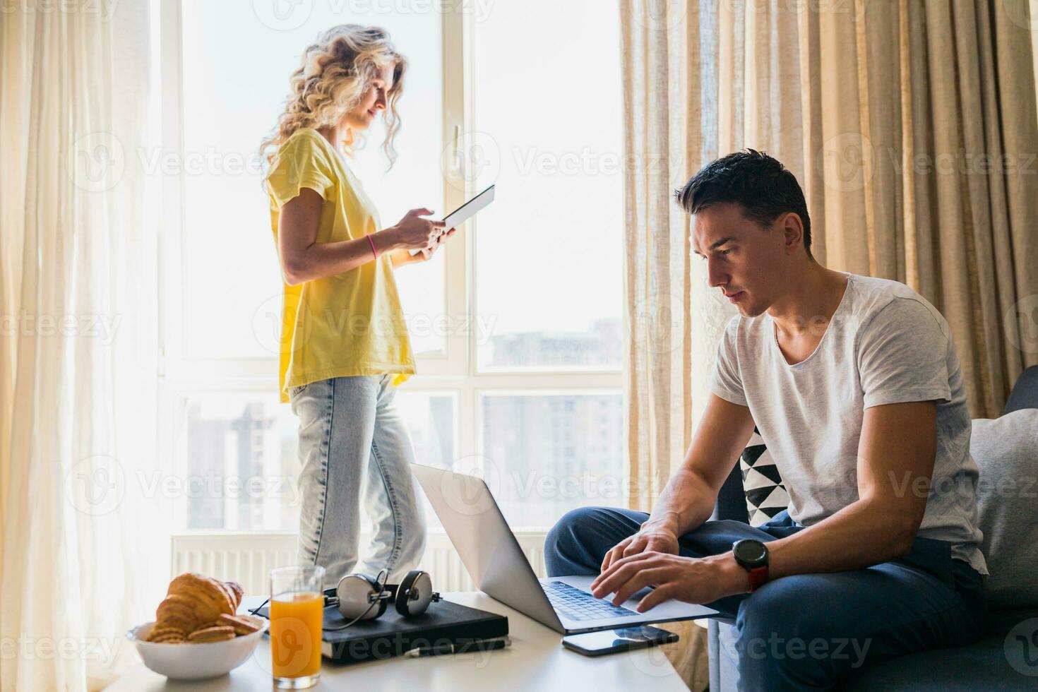 jong Mens en vrouw in liefde zittend Bij huis werken online foto