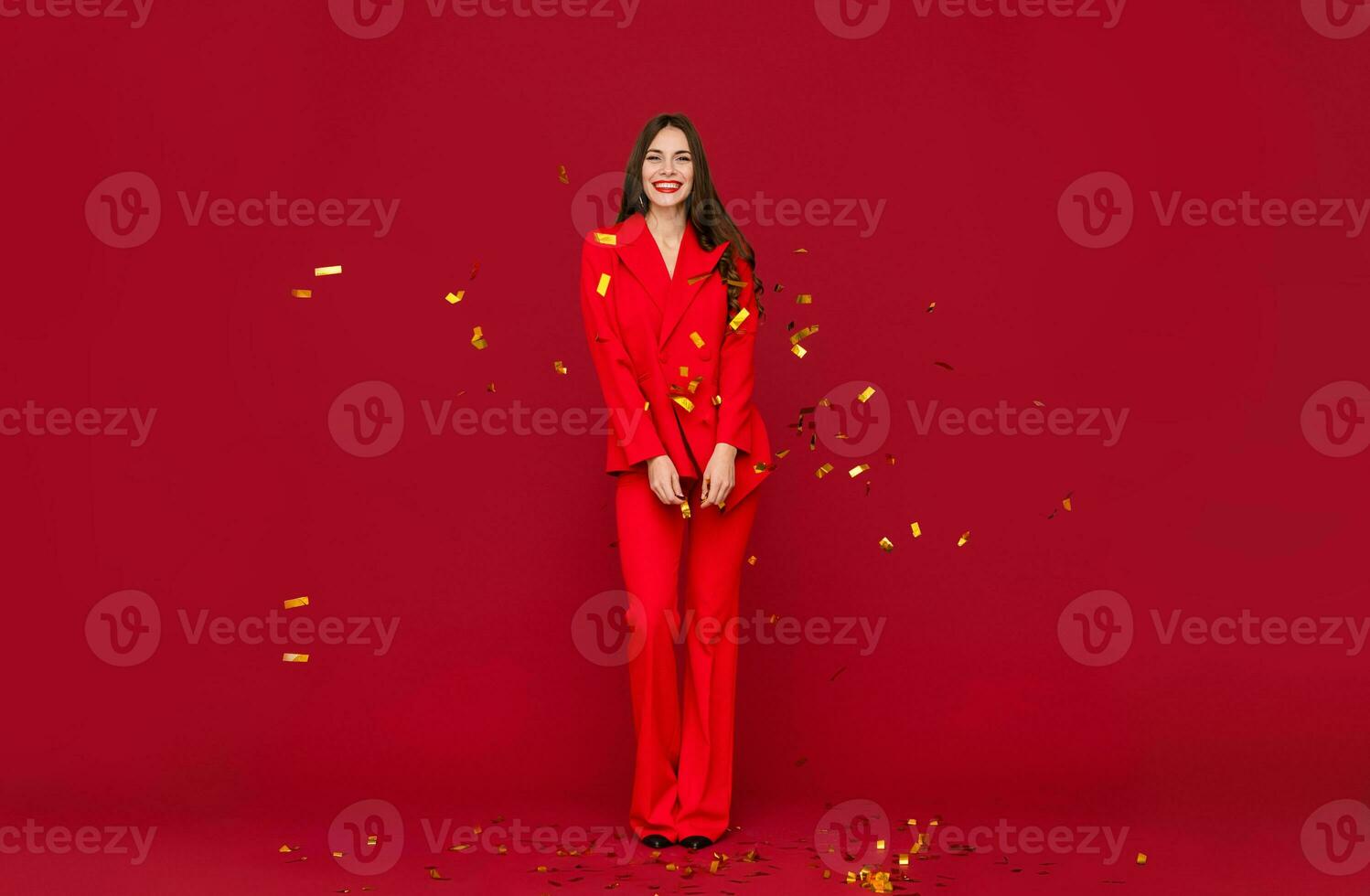 aantrekkelijk vrouw vieren Kerstmis Aan rood achtergrond in confetti foto