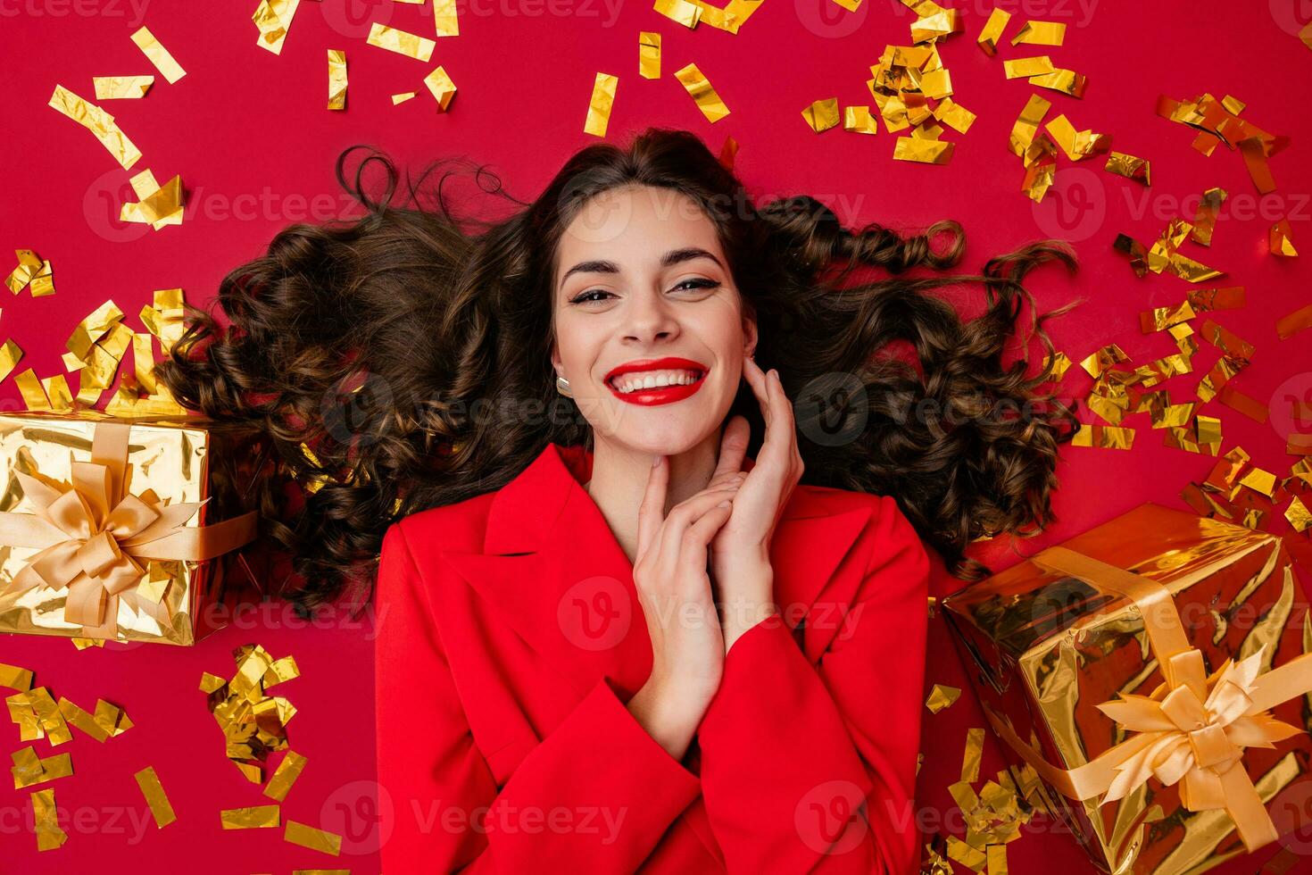 aantrekkelijk vrouw vieren Kerstmis Aan rood achtergrond in confetti foto