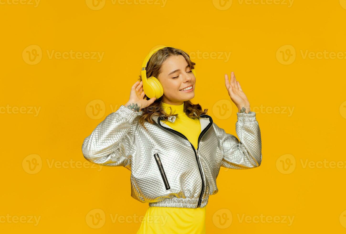 glimlachen aantrekkelijk vrouw luisteren naar muziek- in hoofdtelefoons Aan geel achtergrond foto
