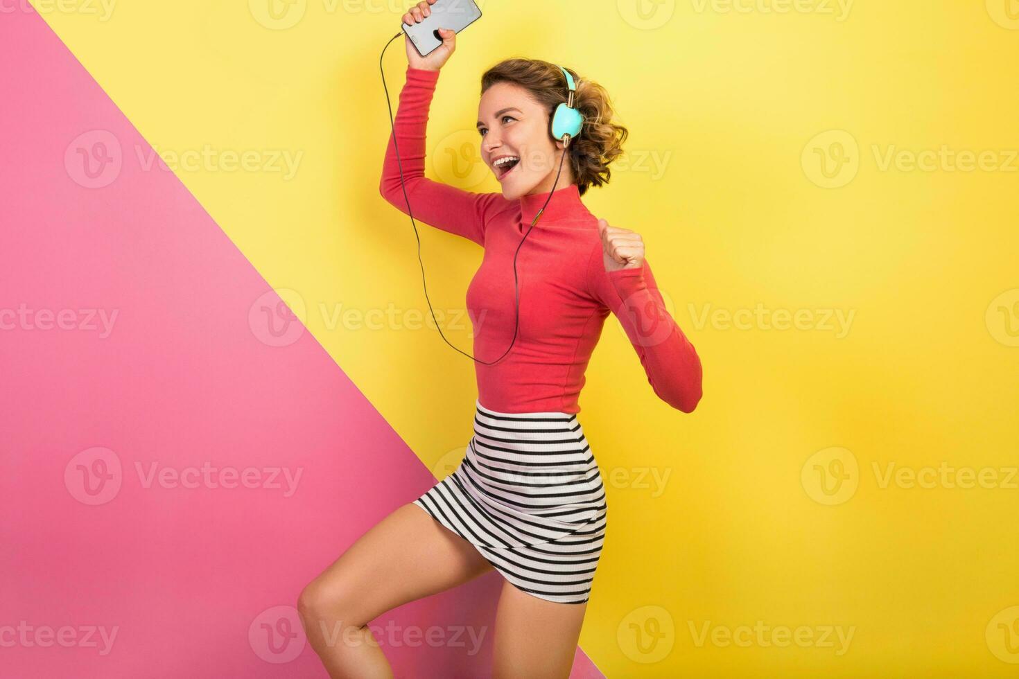 glimlachen aantrekkelijk glimlachen opgewonden vrouw in elegant kleurrijk kleding dansen en luisteren naar muziek- foto