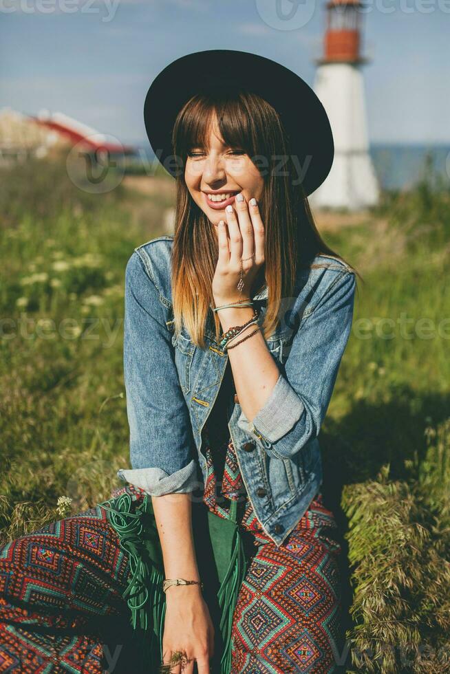 jong vrouw in natuur, vuurtoren denim jasje, zwart hoed, zomer, elegant accessoires foto