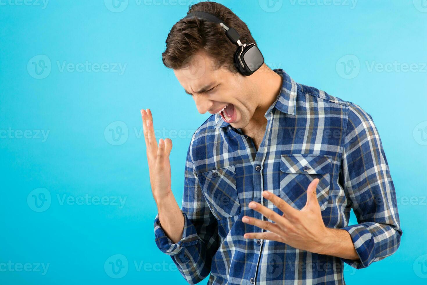 elegant jong Mens luisteren naar muziek- Aan draadloze hoofdtelefoons foto