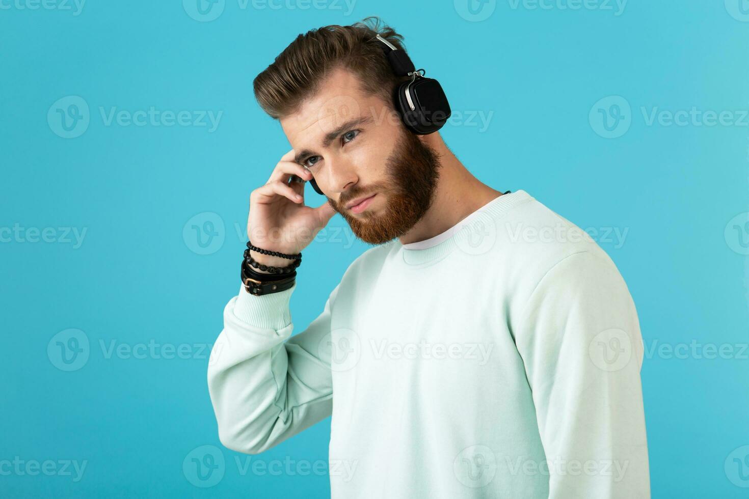 elegant jong Mens luisteren naar muziek- Aan draadloze hoofdtelefoons foto