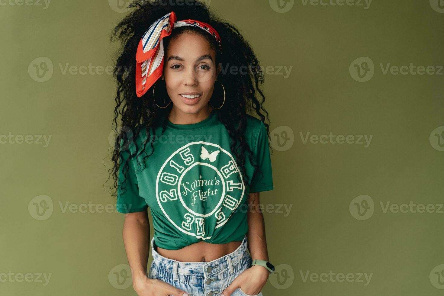 aantrekkelijk zwart Afrikaanse Amerikaans vrouw poseren in elegant hipster kleding Aan groen achtergrond foto