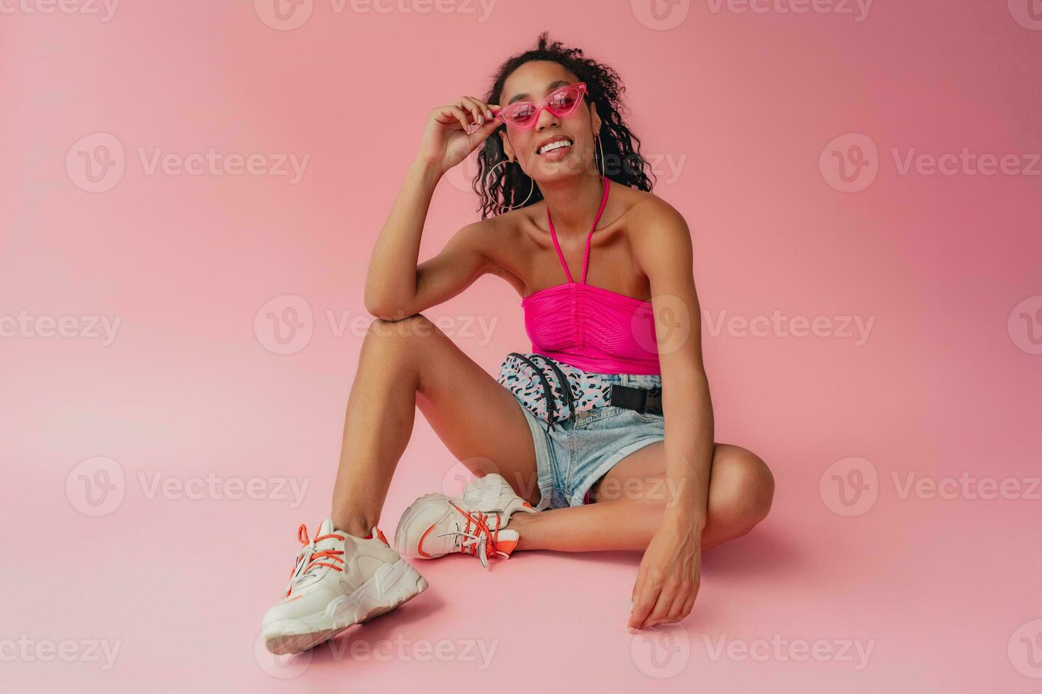 aantrekkelijk zwart Afrikaanse Amerikaans vrouw in elegant kleding Aan roze achtergrond foto