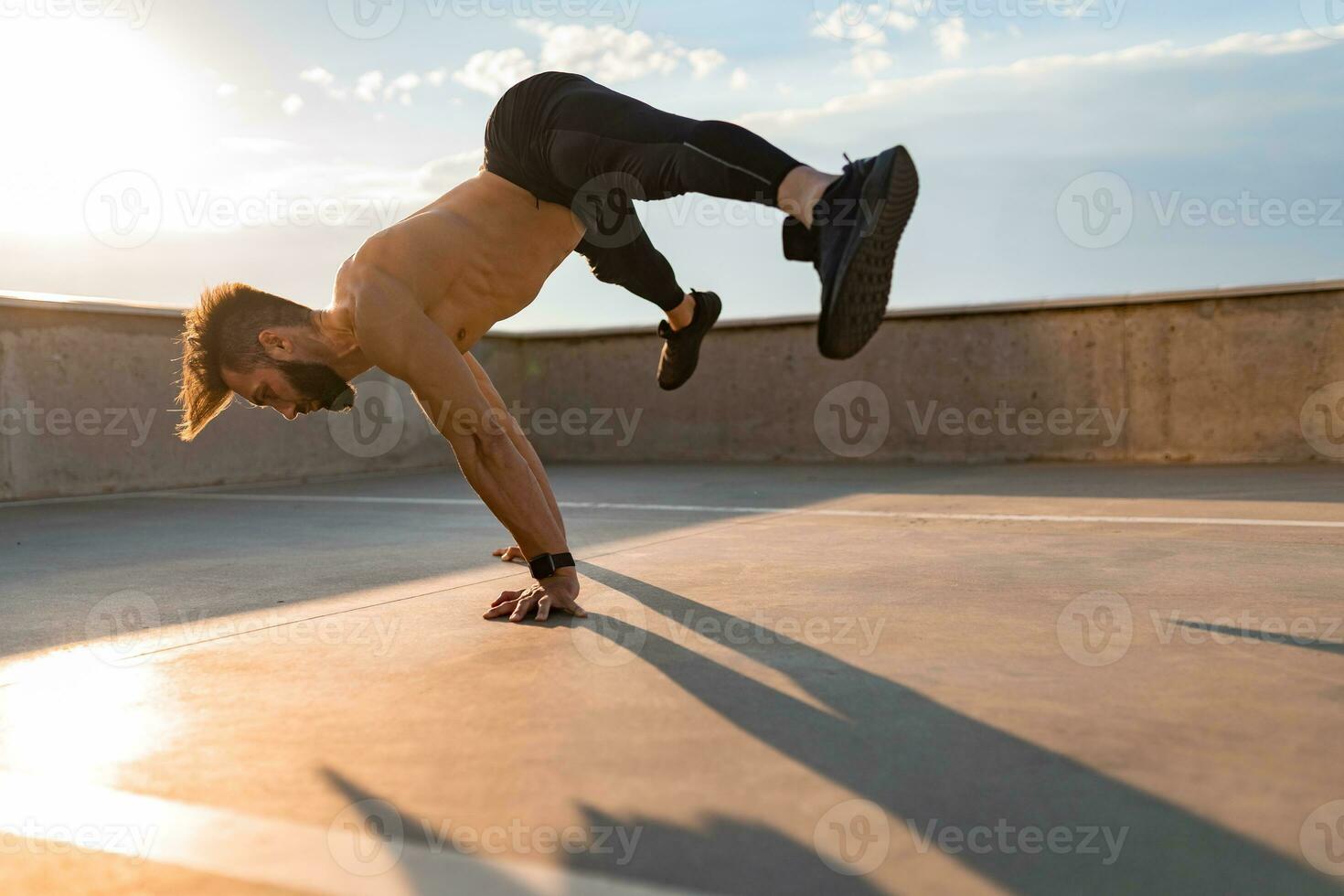 aantrekkelijk knap Mens met atletisch sterk lichaam aan het doen ochtend- yoga asana buitenshuis foto