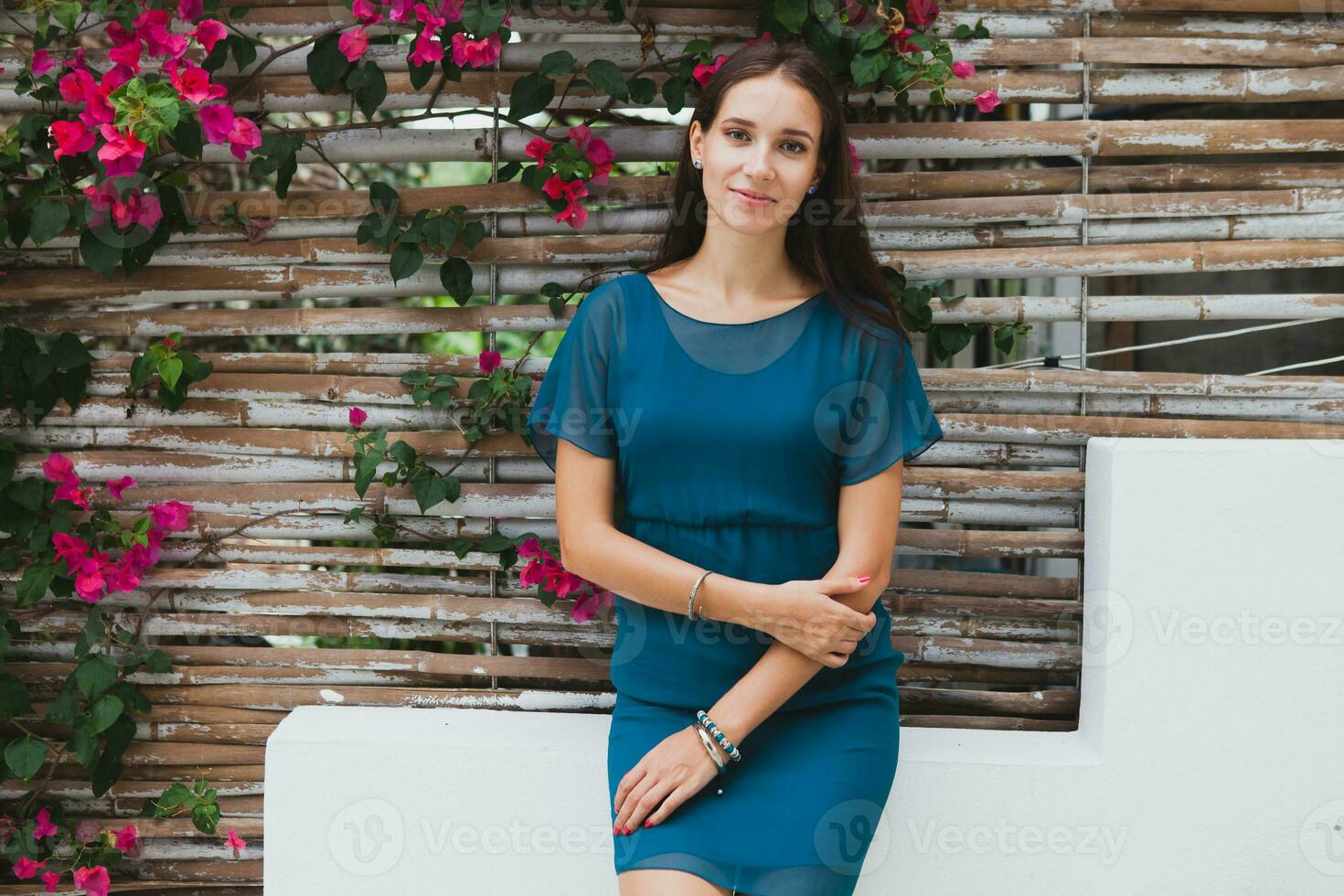 jong elegant mooi vrouw in blauw jurk, zomer mode tendens, vakantie, tuin, tropisch hotel terras, glimlachen foto