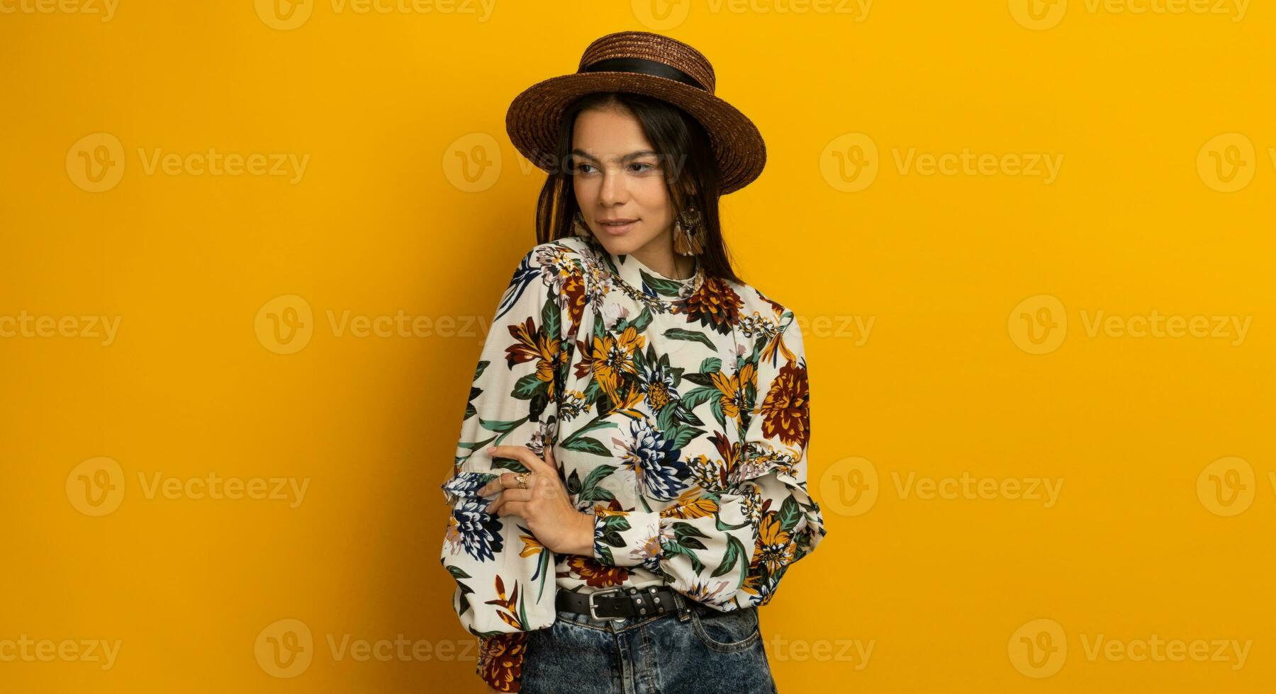 mooi aantrekkelijk elegant brunette vrouw poseren geïsoleerd Aan geel studio achtergrond in modieus mode kleren kleding, gedrukt blouse en hoed, glimlachen Vrolijk, accessoires foto