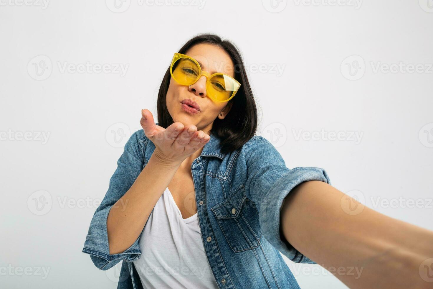 aantrekkelijk vrouw gekleed jeans en denim overhemd vervelend geel zonnebril foto