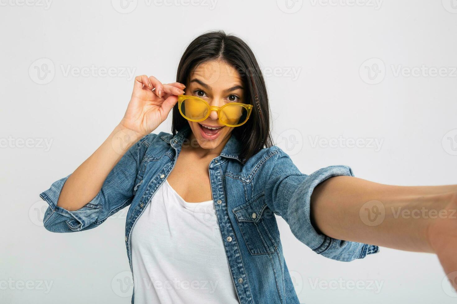 aantrekkelijk vrouw gekleed jeans en denim overhemd vervelend geel zonnebril foto