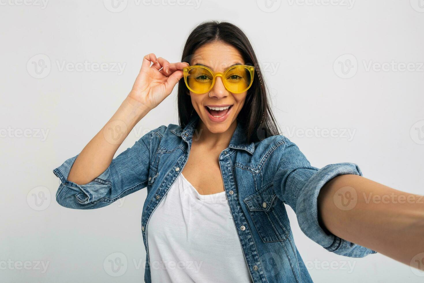 aantrekkelijk vrouw gekleed jeans en denim overhemd vervelend geel zonnebril foto