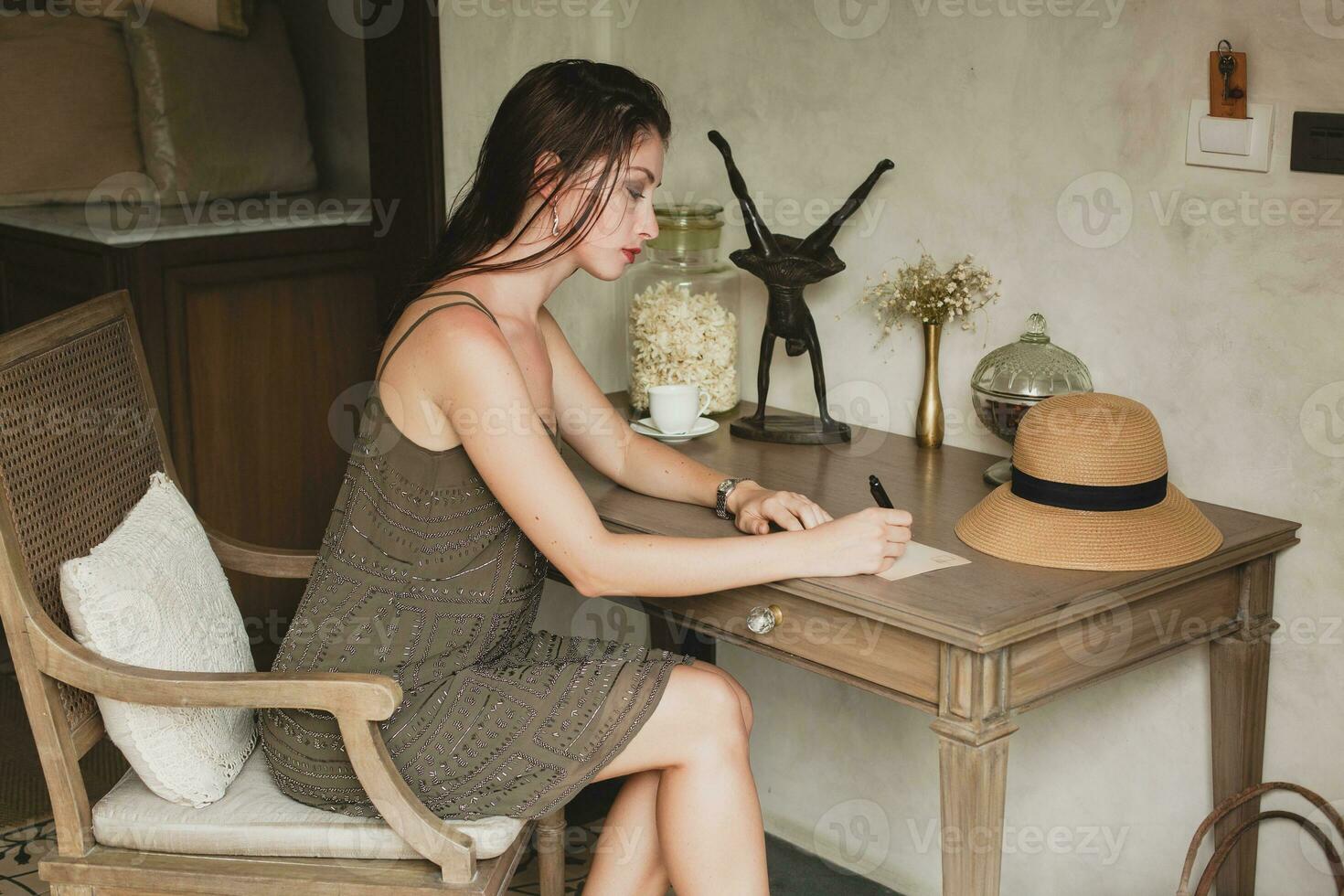 jong elegant mooi vrouw zittend Bij tafel in toevlucht hotel kamer foto