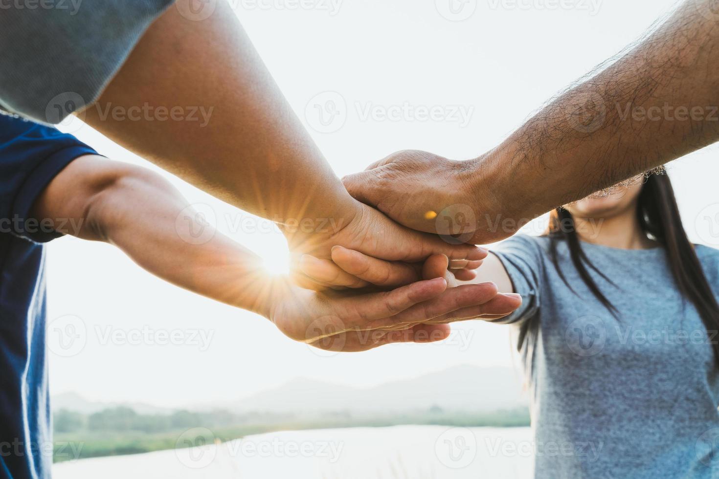 mensen slaan de handen ineen. vrienden met stapel handen die eenheid en teamwork tonen. vriendschap geluk vrije tijd partnerschap team concept. foto