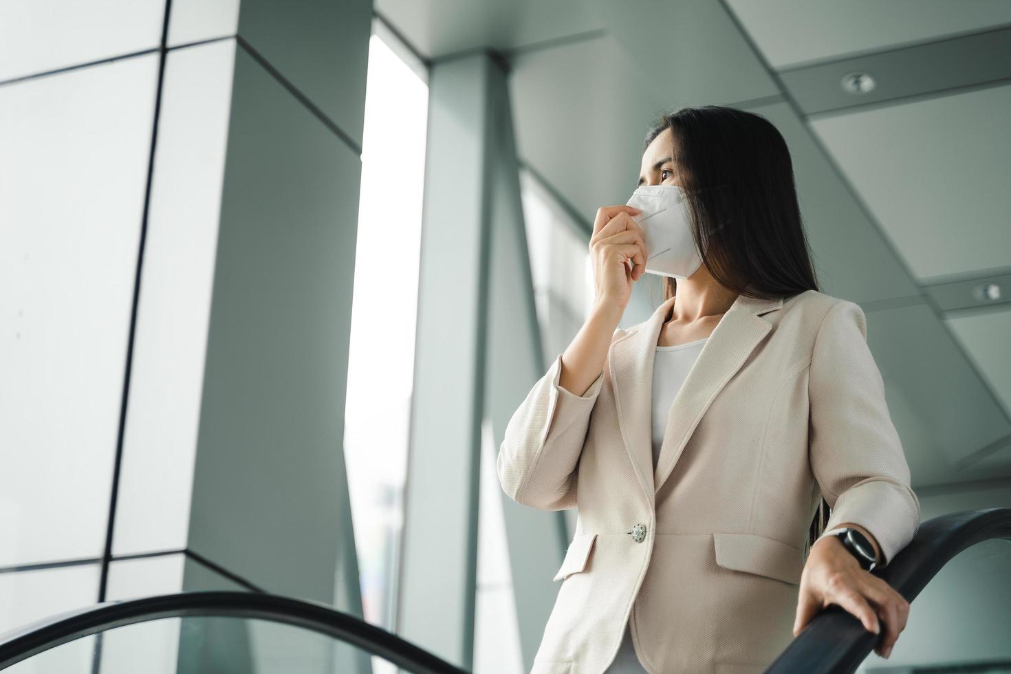 aziatische vrouw die n95-masker draagt om vervuiling pm2.5 en virus te beschermen. covid-19 coronavirus en luchtvervuiling pm2.5 concept. foto