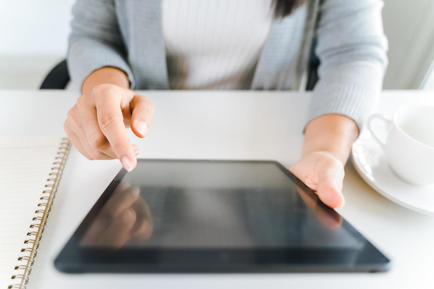 close-up van jonge vrouwen die digitale tablet gebruiken om op kantoor te werken. foto