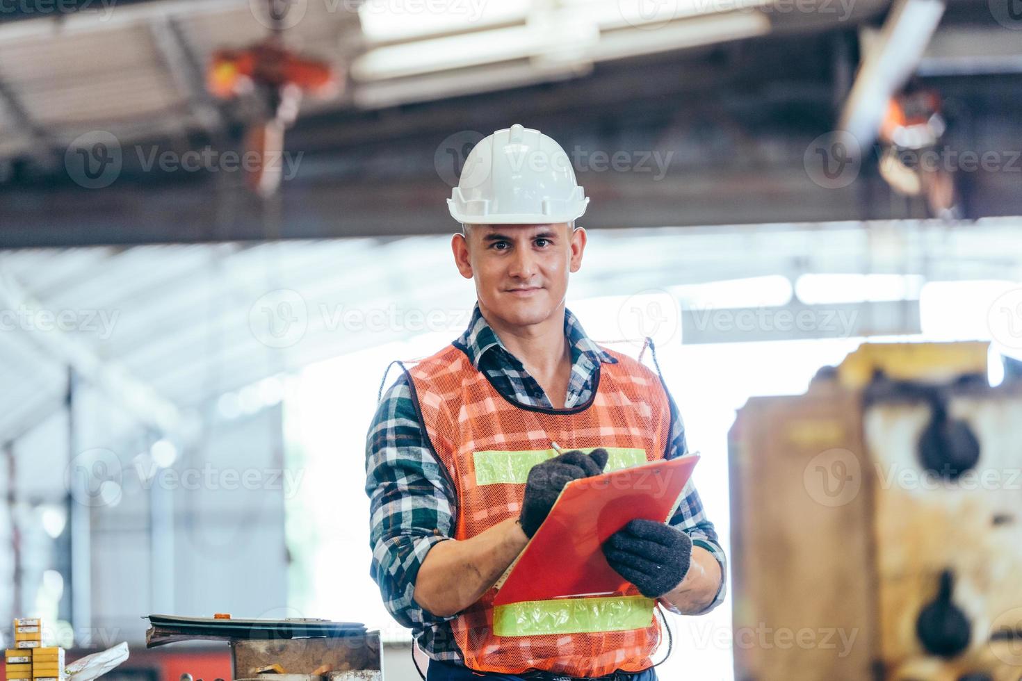 portret van ingenieursvoorman in veiligheidshelm die bij fabriek werkt foto