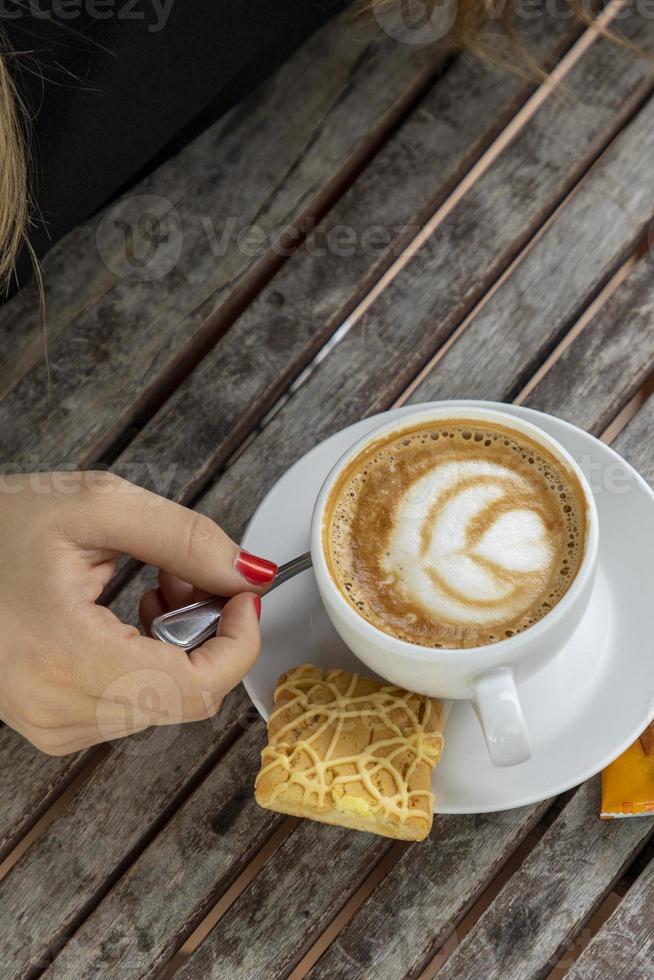 vrouw die een cappuccino drinkt foto