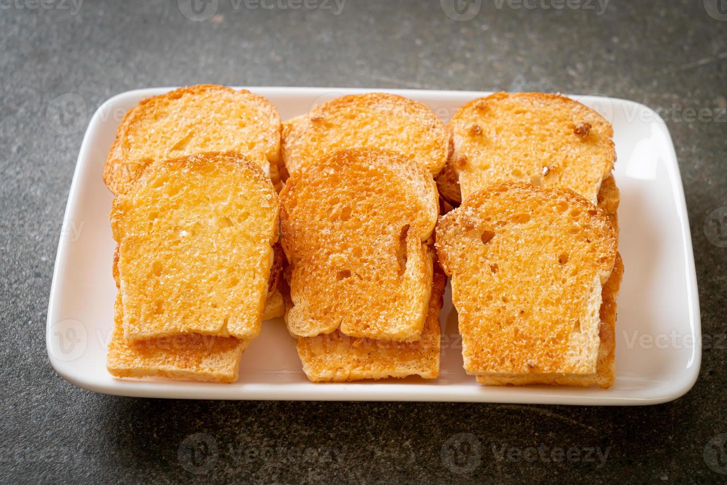 gebakken krokant brood met boter en suiker op bord foto