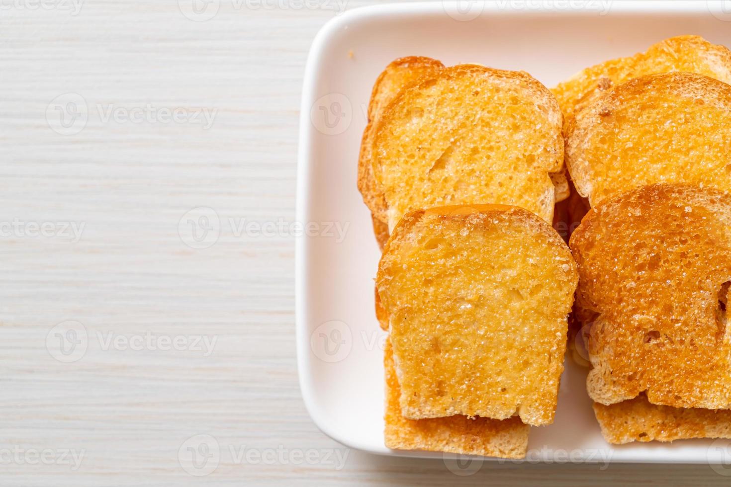 gebakken krokant brood met boter en suiker op bord foto
