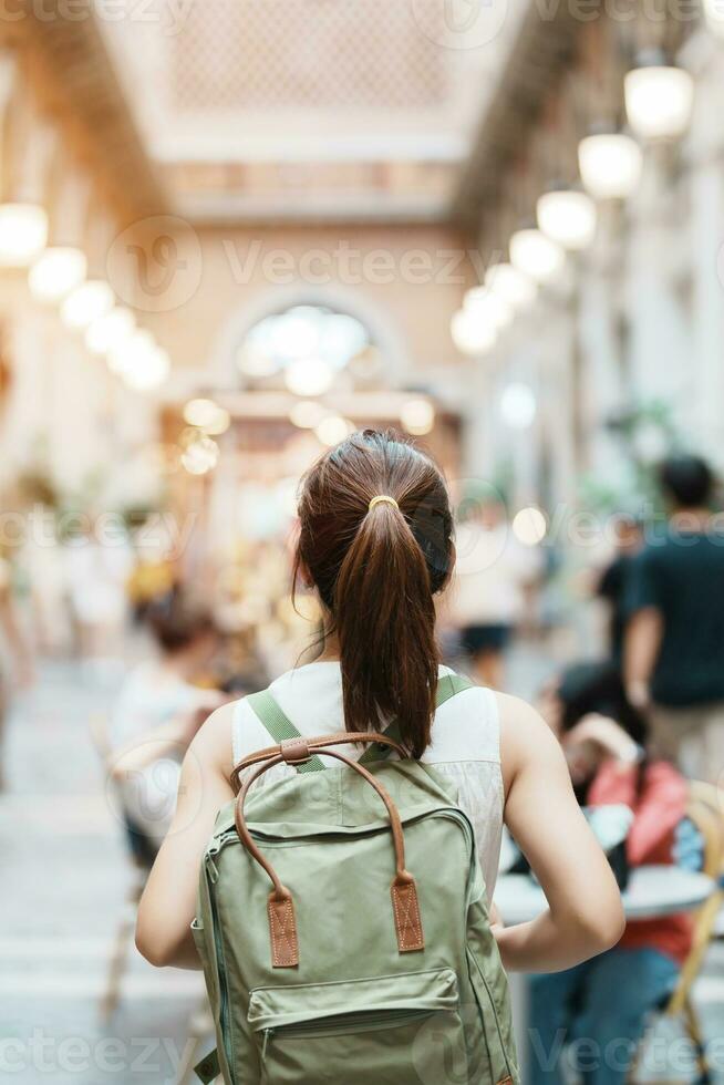 jong Aziatisch vrouw reiziger in geel jurk met zak op reis naar nimman Aan nimmanhaemin weg, toerist bezoek Bij de nacht markt stad in chang mei, Thailand. Azië reis, vakantie en zomer vakantie foto