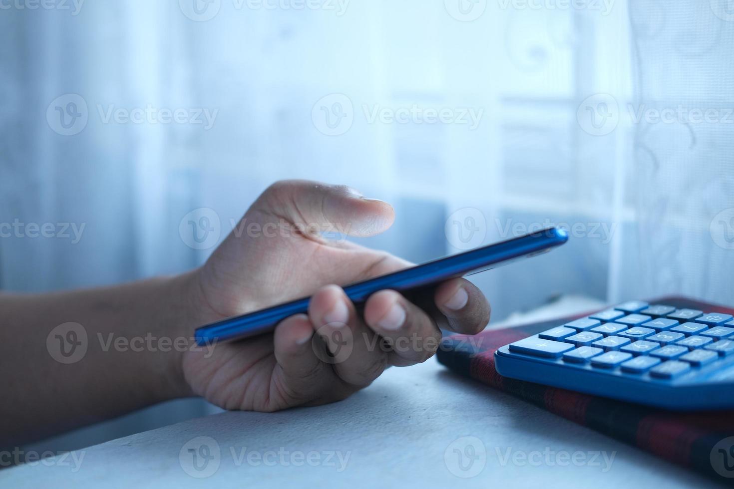 close-up van de hand van een jonge man met behulp van slimme telefoon in de vroege ochtend foto