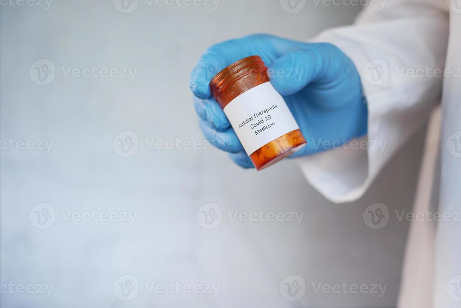 hand in latex handschoenen met covid 19 medische pillen container foto
