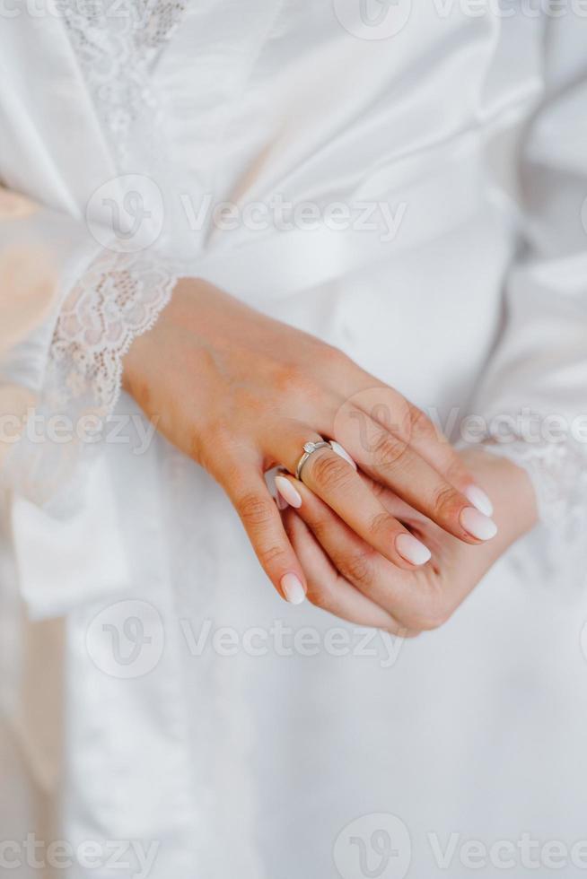 de bruid raakt zachtjes haar geliefde verlovingsring aan foto