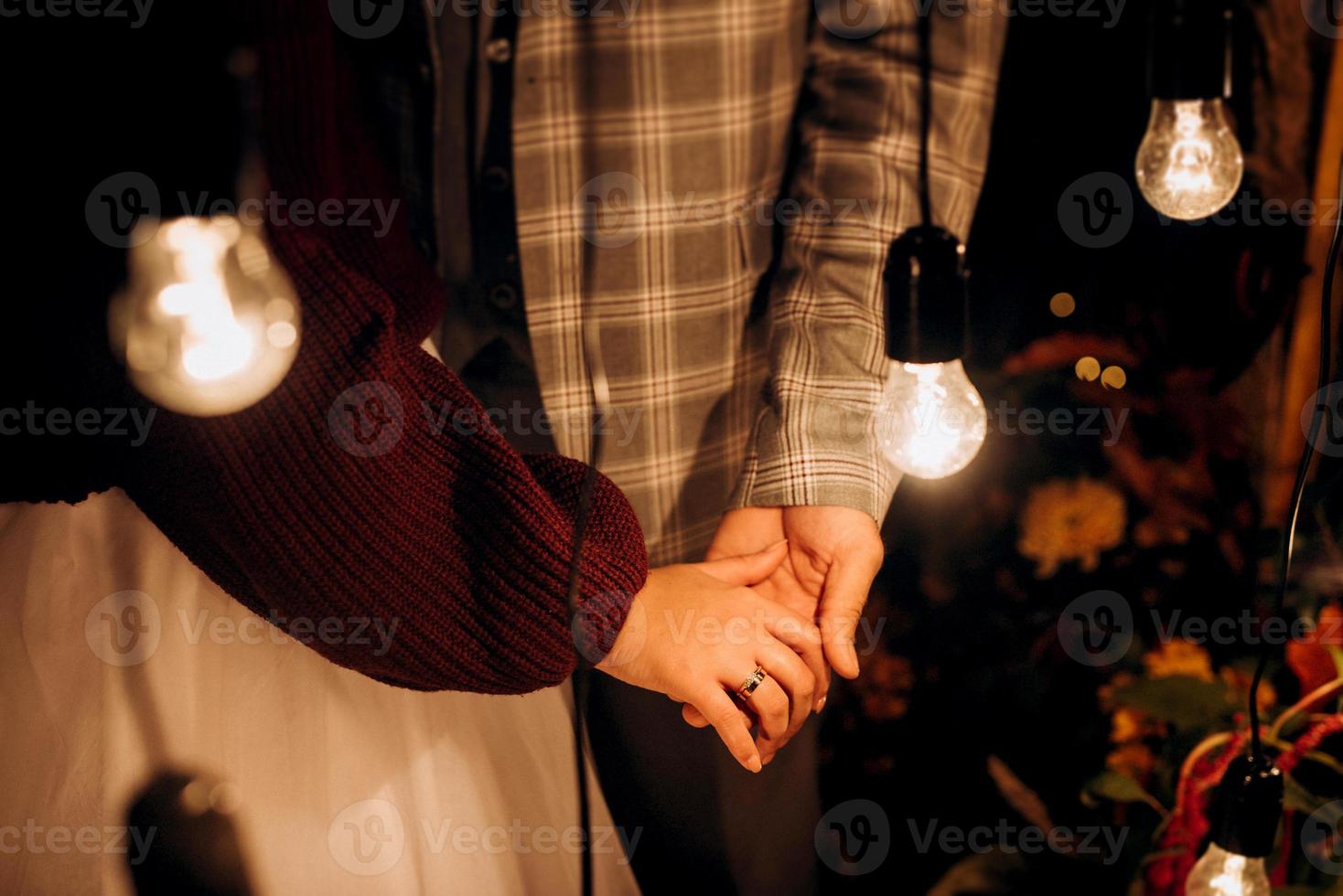 de bruid en bruidegom houden teder de handen vast tussen hen liefde en relaties foto