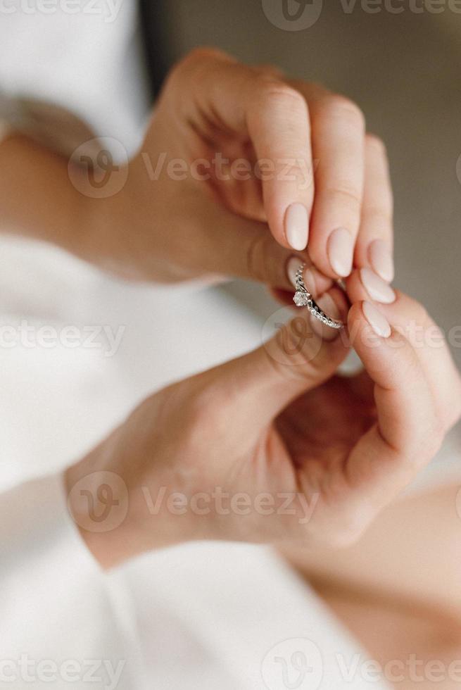 de bruid houdt een verlovingsring met edelstenen vast foto