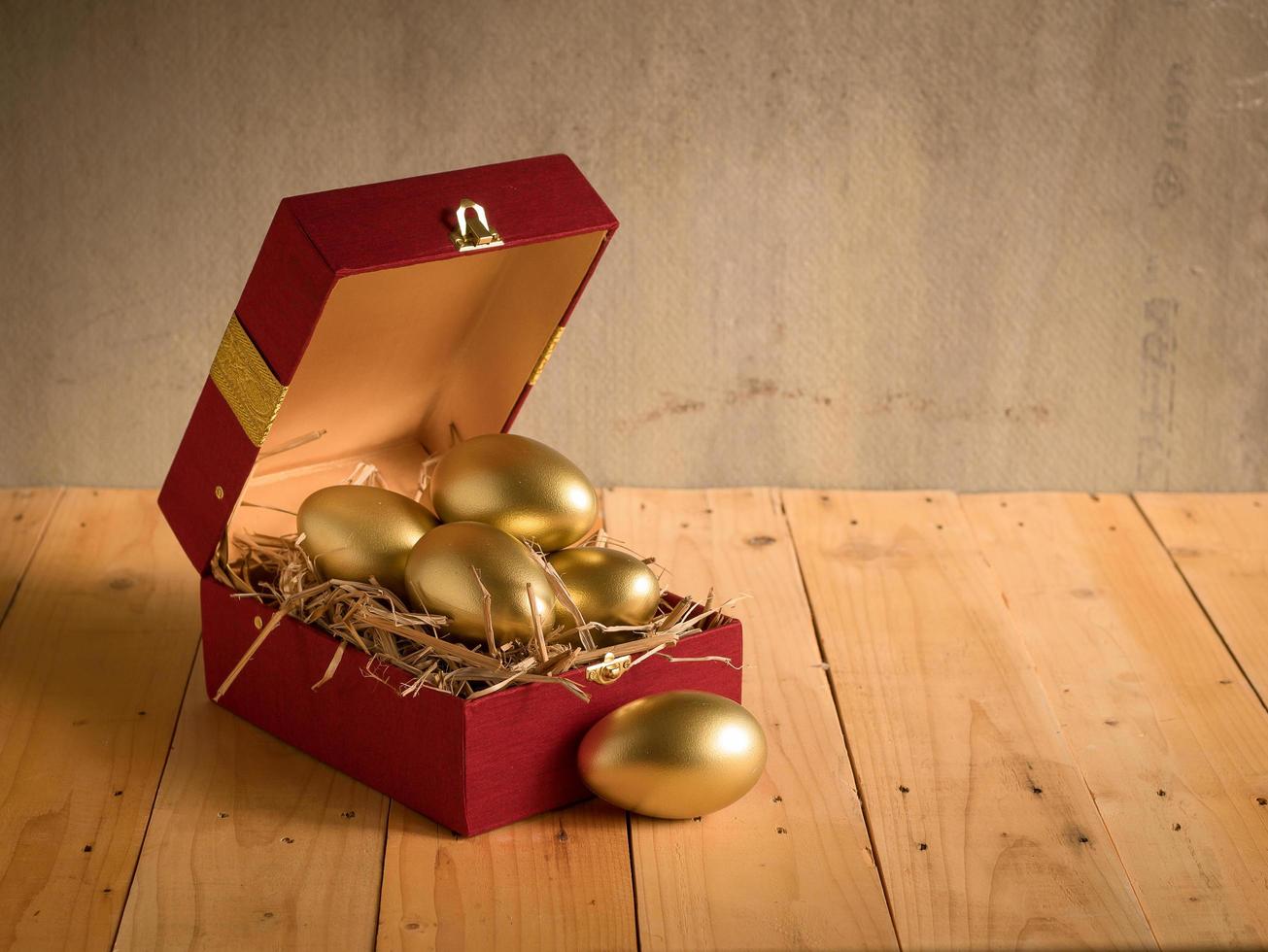financieel succes. gouden ei in een rode geschenkdoos foto