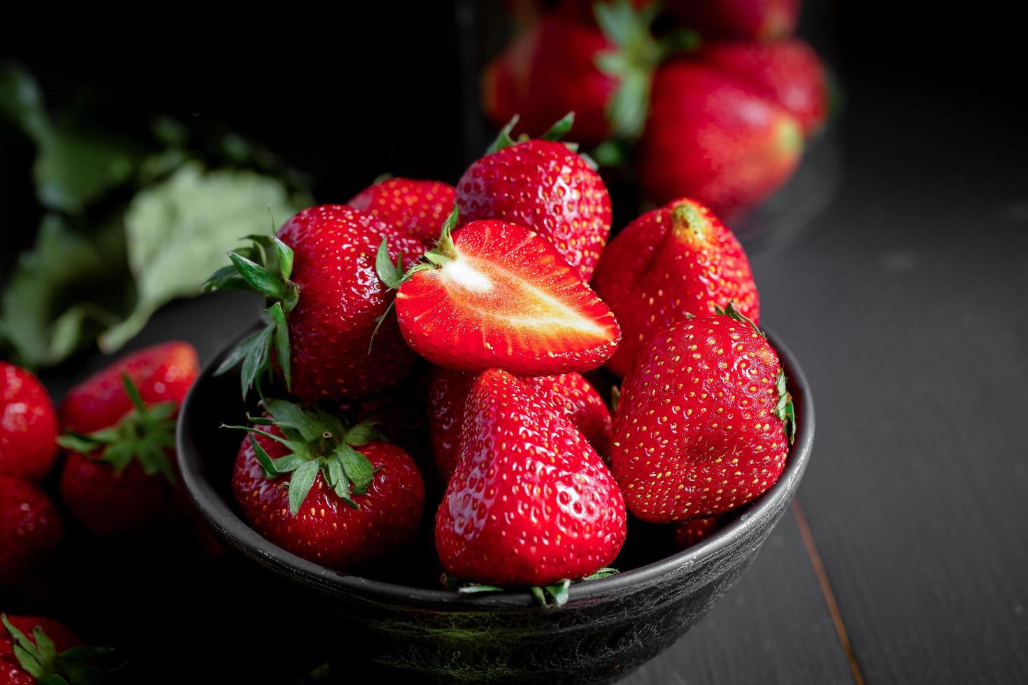 rijpe rode aardbeien op zwarte houten tafel foto