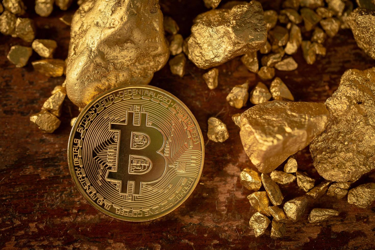 gouden bitcoin fysieke bitcoin-cryptocurrency en goudklompkorrels. bedrijfsconcept foto