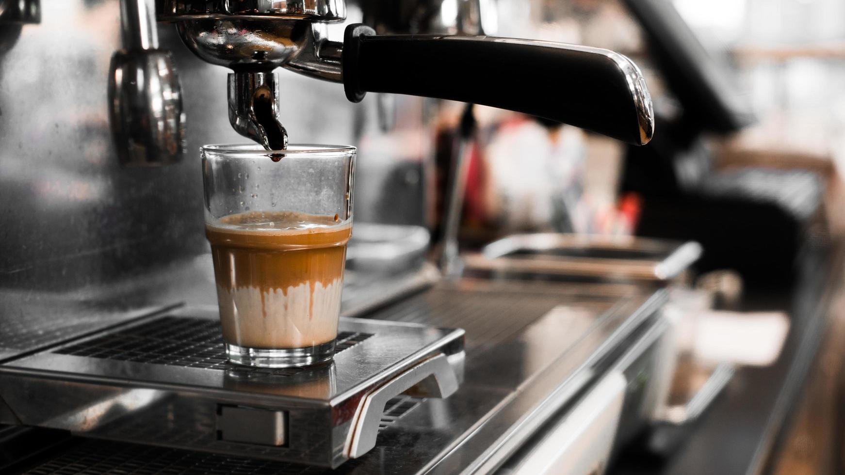 zwarte koffie met melk op koffiezetapparaat foto