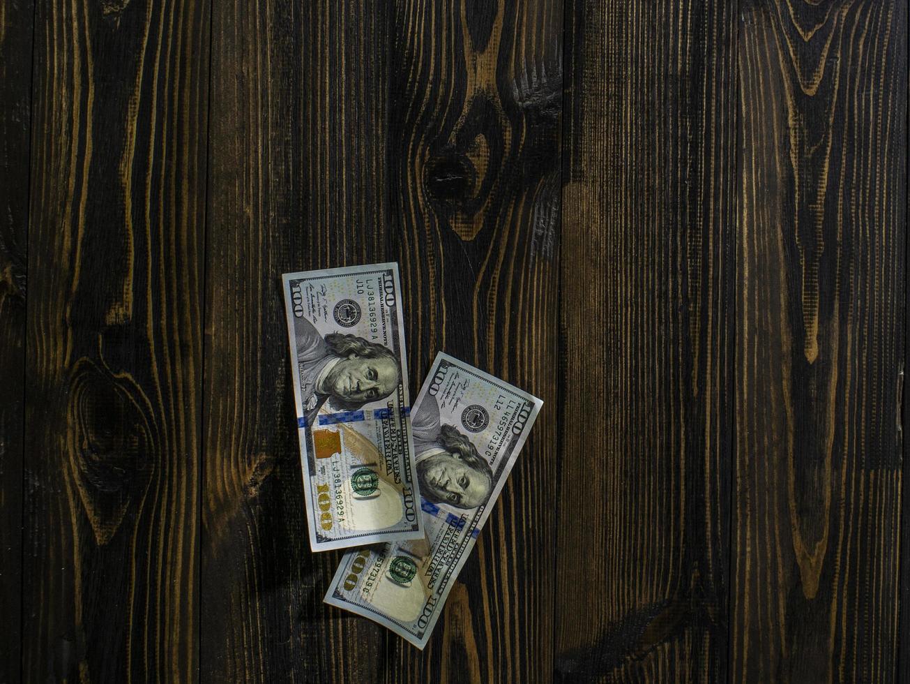 tweehonderd dollar biljetten op een houten achtergrond. nieuwe honderd dollar biljet. close-up Amerikaanse dollarbankbiljetten bank foto