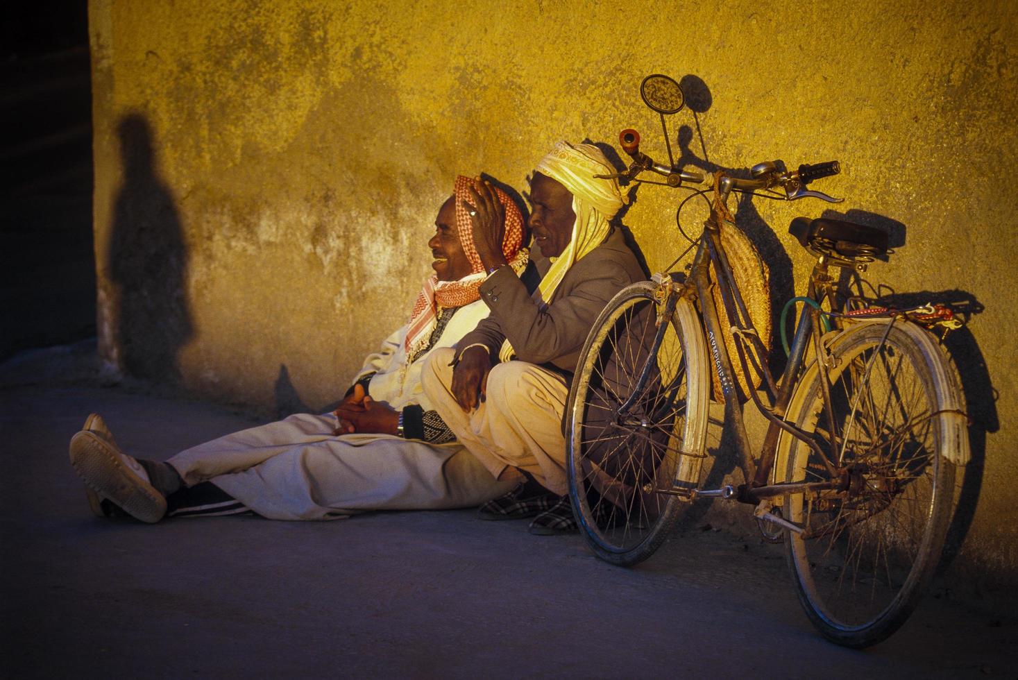 tamanrasset, algerije 2010- onbekende persoon zit met zijn fiets foto