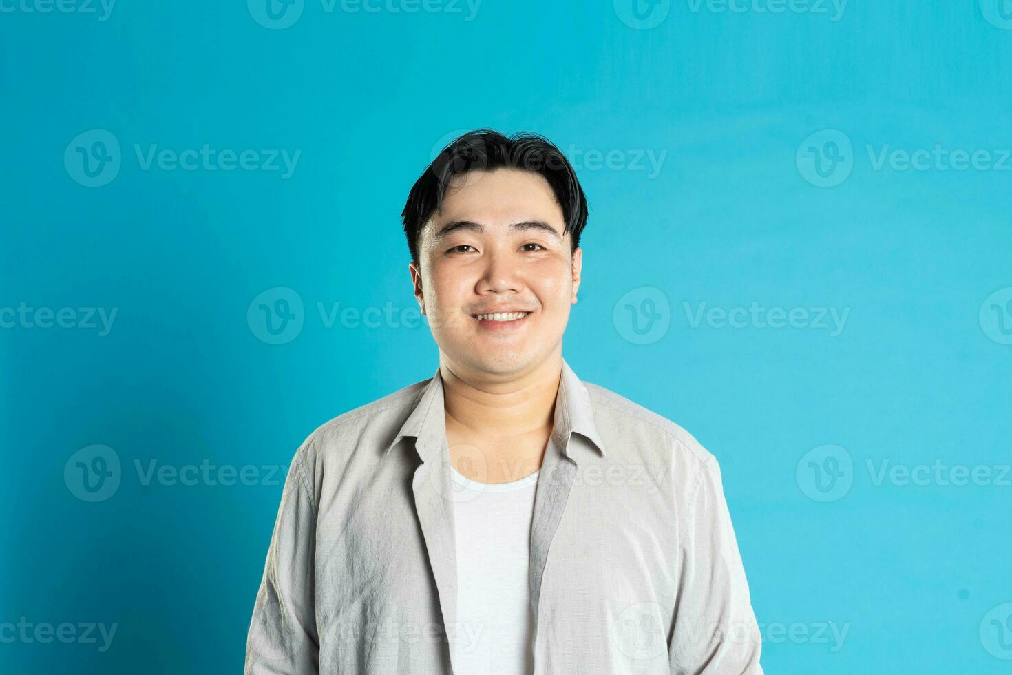 portret van een Aziatisch vent poseren Aan een blauw achtergrond foto
