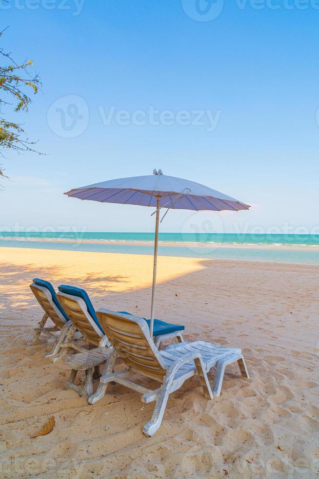 lege strandstoel op zand met oceaanzeeachtergrond foto