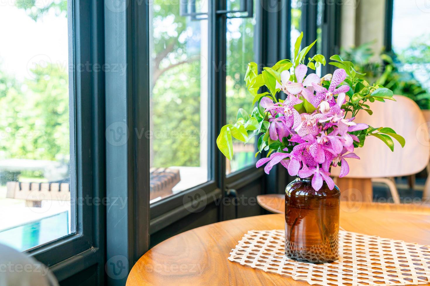 orchidee bloemen in vaas decoratie op tafel in coffeeshop café restaurant foto
