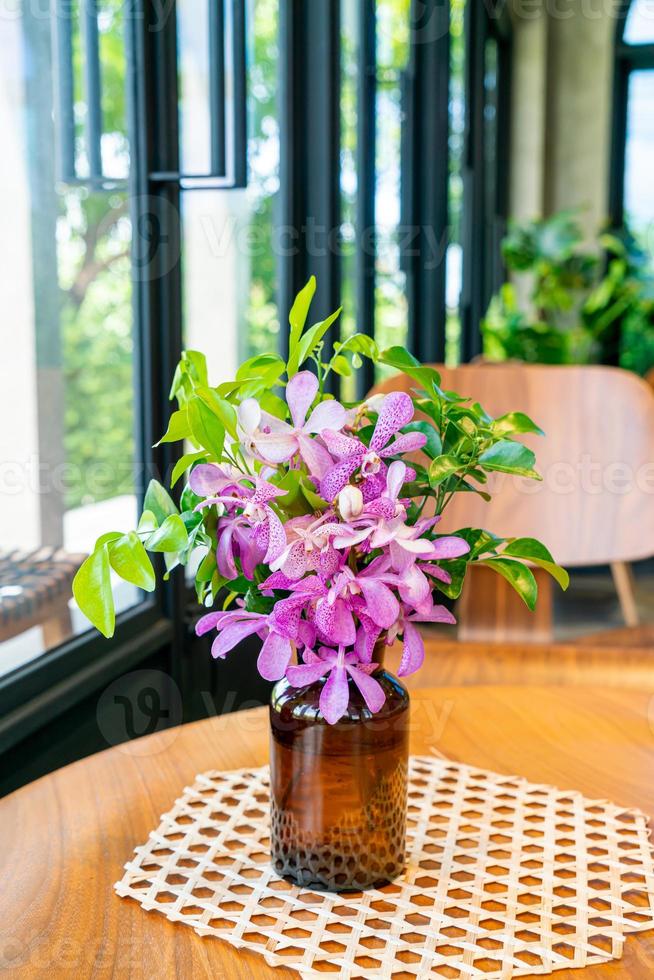 orchidee bloemen in vaas decoratie op tafel in coffeeshop café restaurant foto