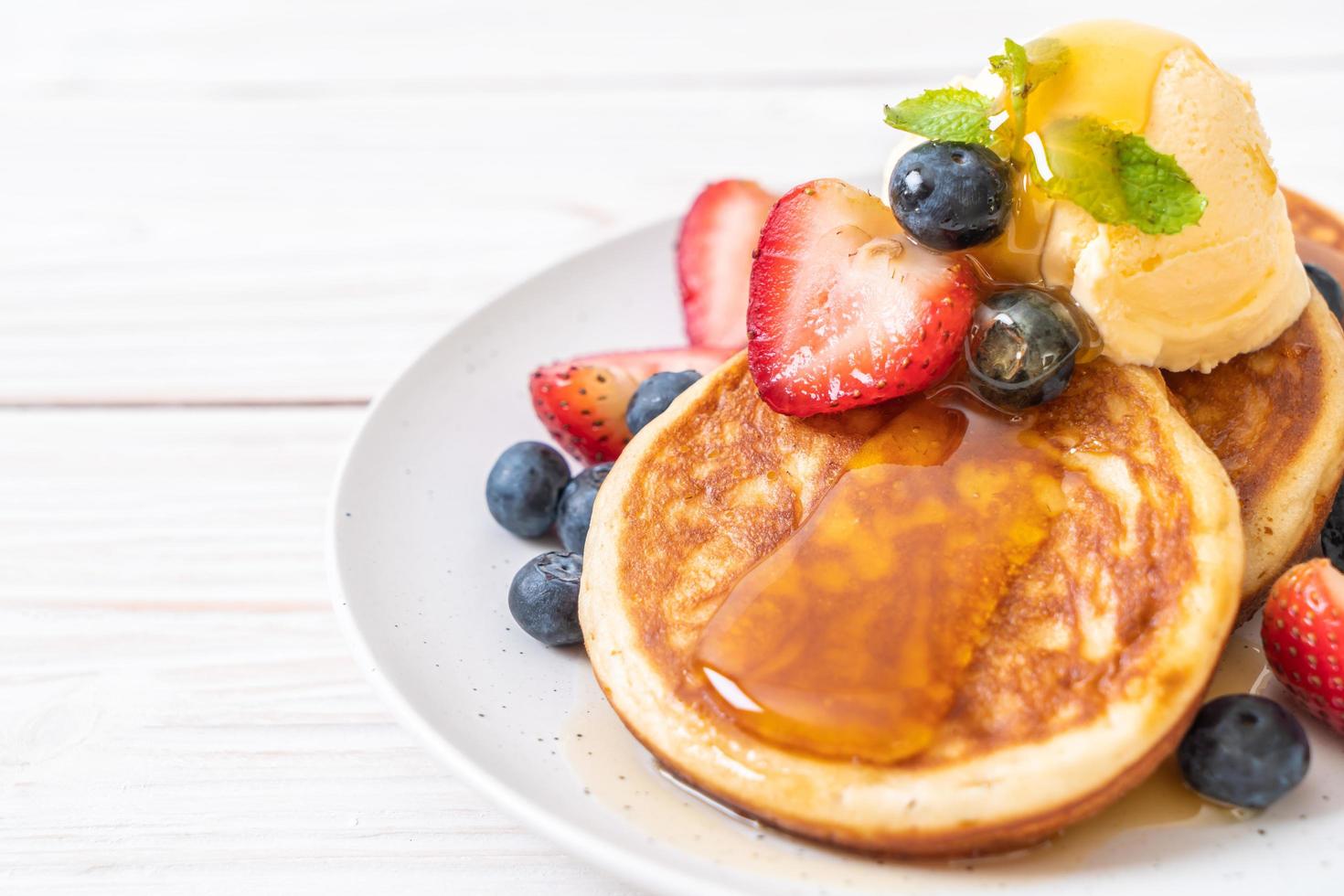 soufflépannenkoek met bosbessen, aardbeien, honing en vanille-ijs foto