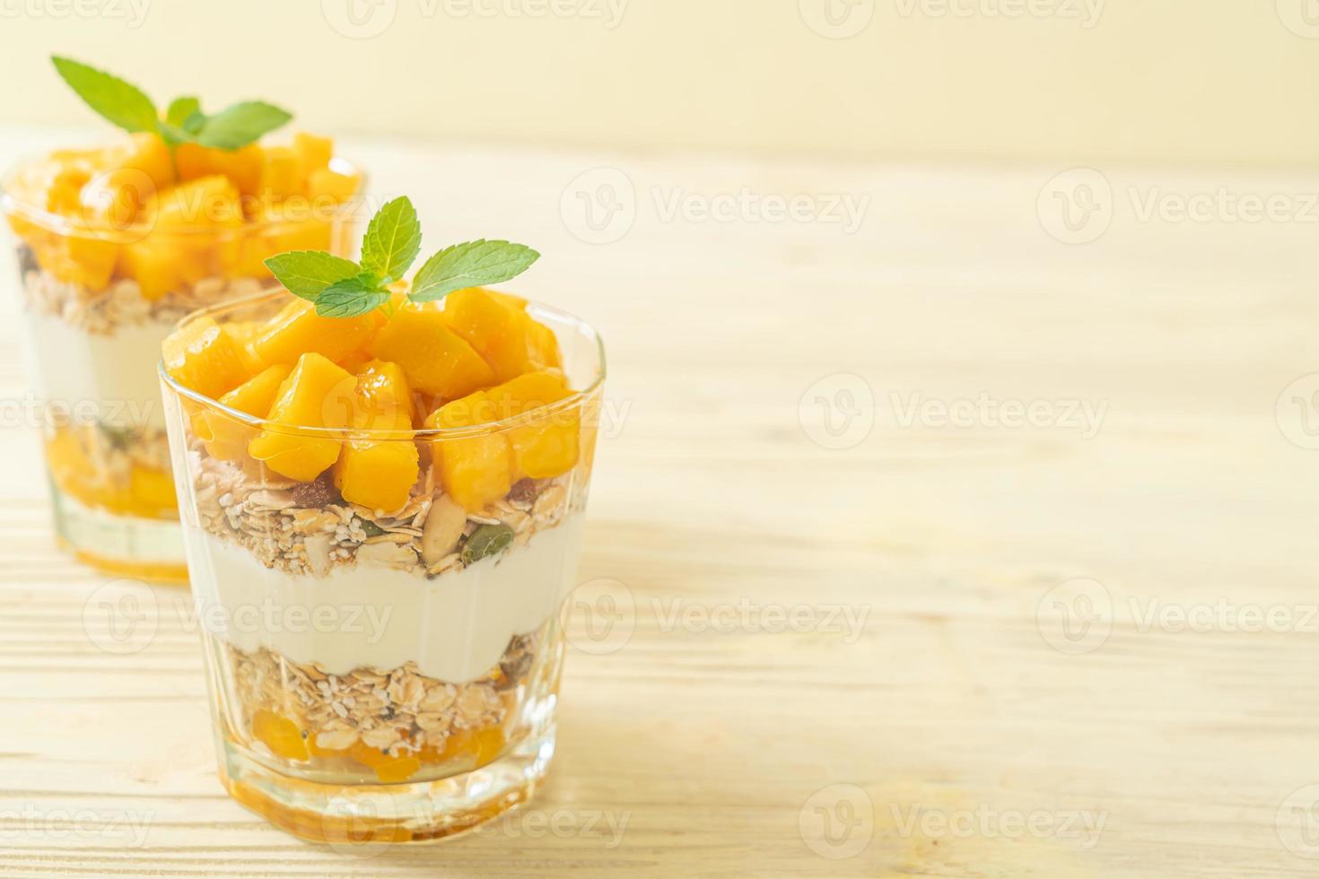 verse mangoyoghurt met muesli in glas - gezonde voedingsstijl foto