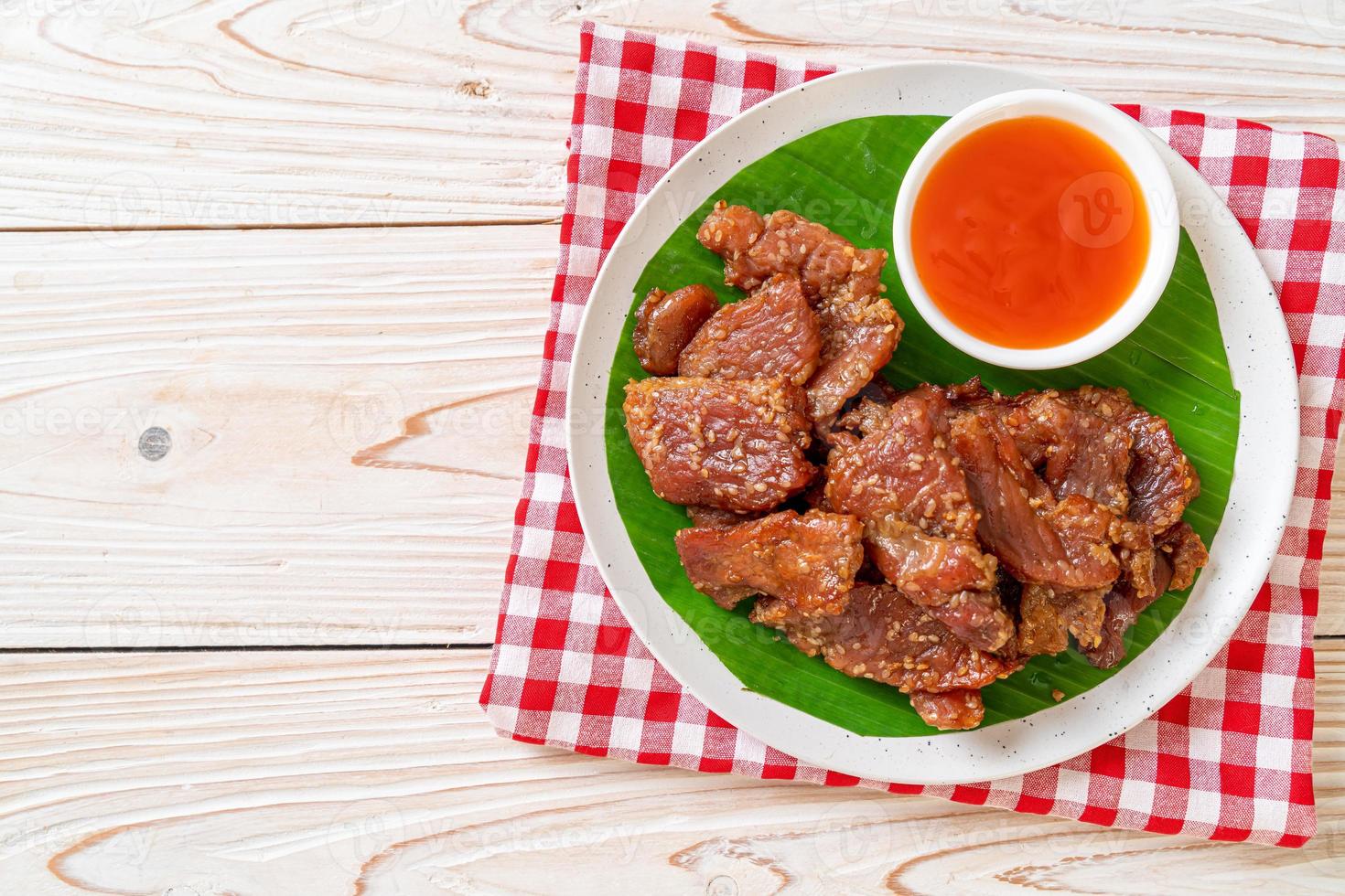 zongedroogd varkensvlees met saus op bord foto