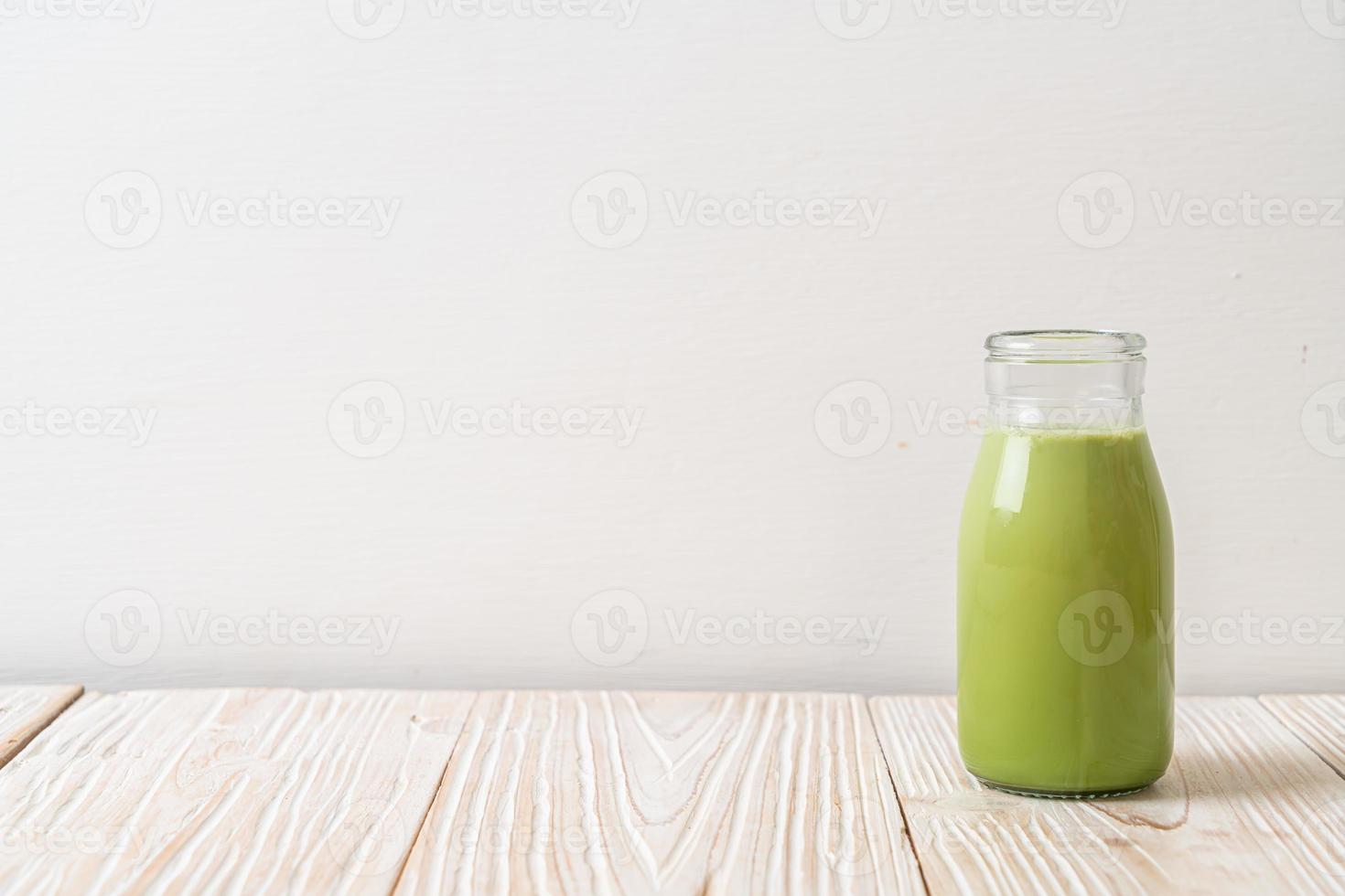 matcha groene thee met melk in fles op hout achtergrond foto