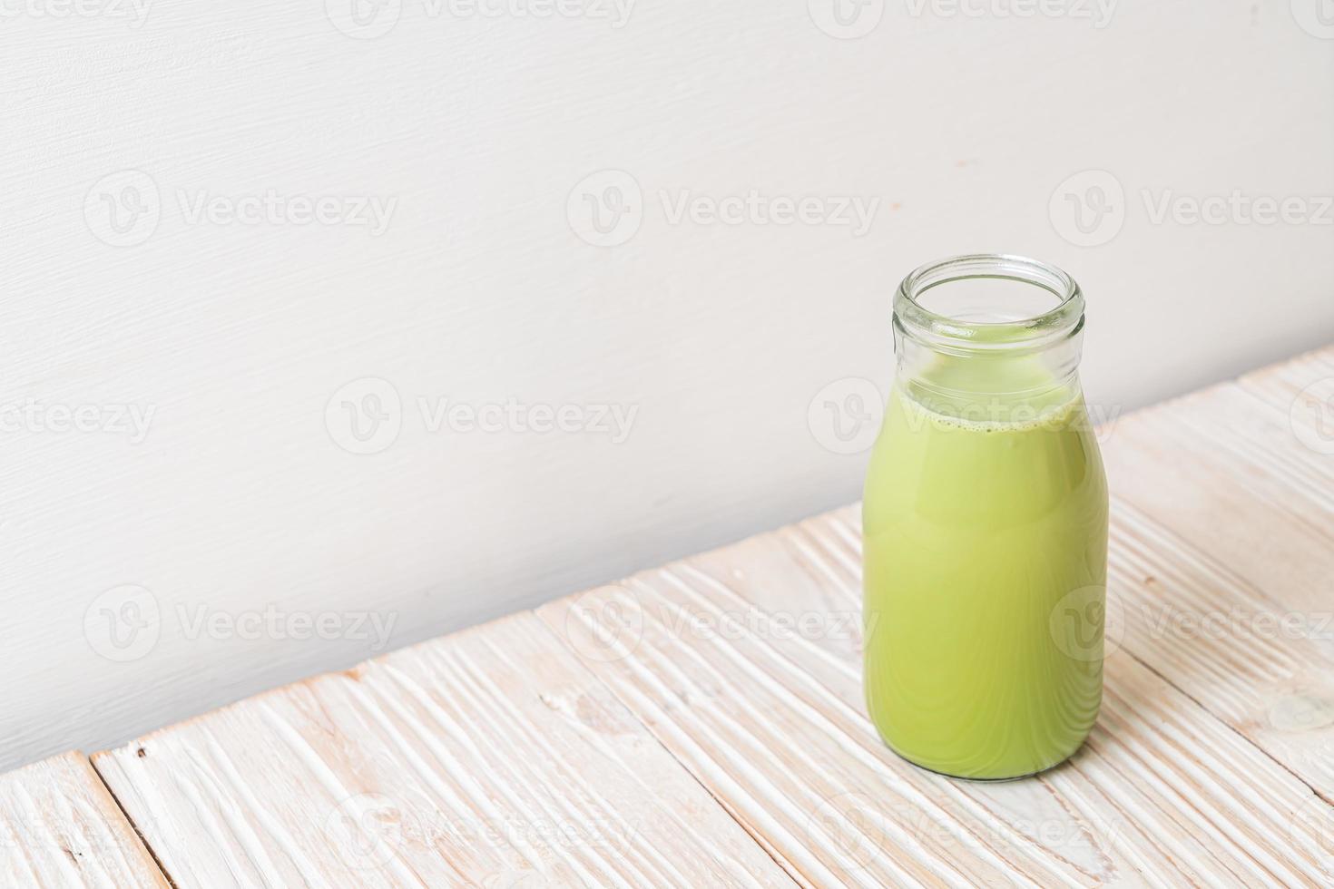 matcha groene thee met melk in fles op hout achtergrond foto